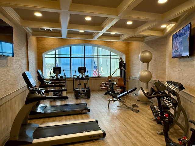 gym featuring hardwood / wood-style floors, coffered ceiling, and wood walls