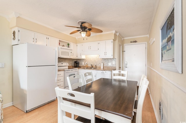 kitchen with white cabinets, white appliances, sink, and a textured ceiling