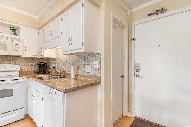 kitchen featuring white appliances, backsplash, crown molding, sink, and white cabinetry