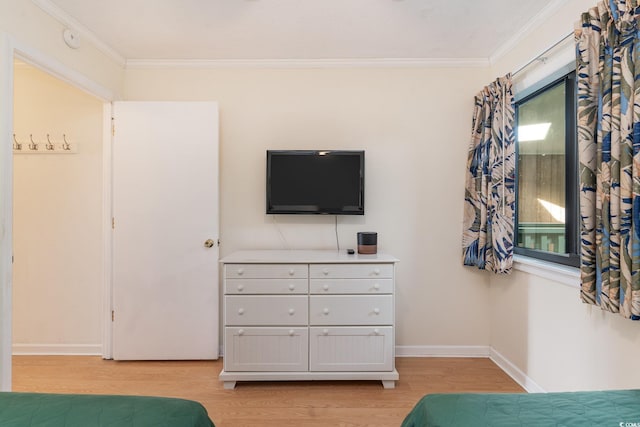 bedroom with light wood-type flooring and crown molding