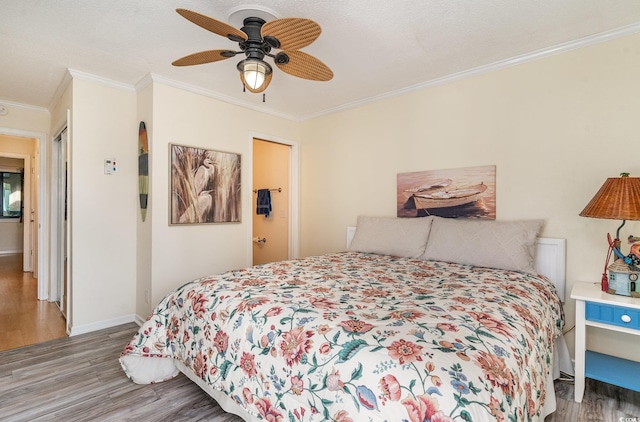 bedroom with hardwood / wood-style flooring, ceiling fan, and ornamental molding