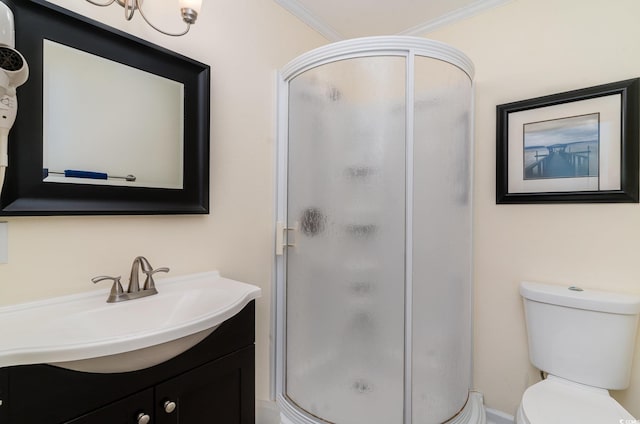 bathroom with vanity, toilet, a shower with door, and crown molding