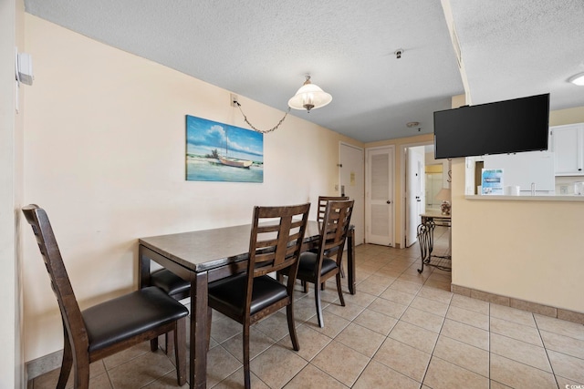 tiled dining space featuring a textured ceiling