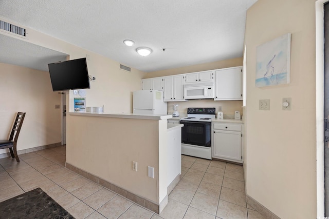 kitchen featuring a textured ceiling, white cabinetry, light tile patterned floors, and white appliances