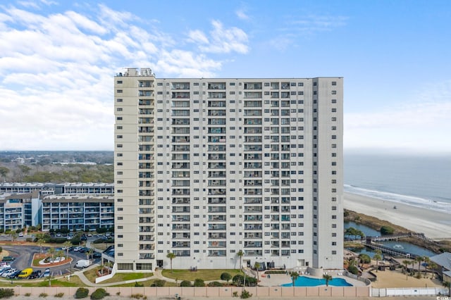 view of property with a water view and a view of the beach