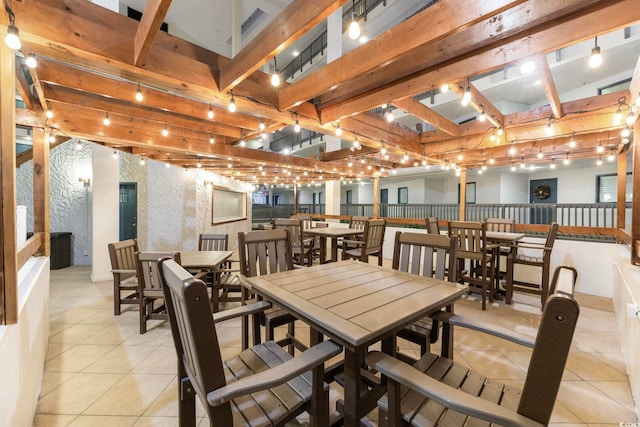 tiled dining area featuring beamed ceiling