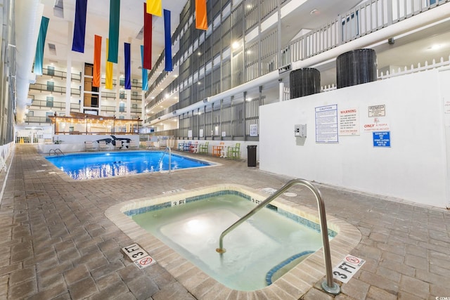 view of swimming pool with a hot tub