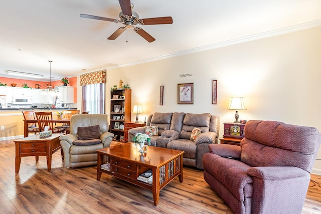 living room featuring ceiling fan, crown molding, and light hardwood / wood-style floors