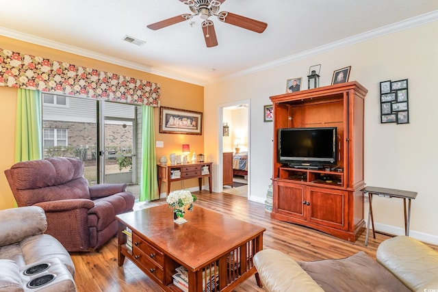 living room featuring ceiling fan, crown molding, and light hardwood / wood-style floors