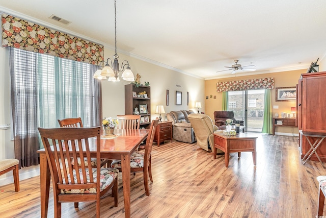 dining area with ceiling fan with notable chandelier, light hardwood / wood-style floors, and crown molding