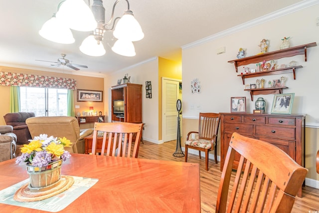 dining area with ceiling fan with notable chandelier, light hardwood / wood-style flooring, and crown molding