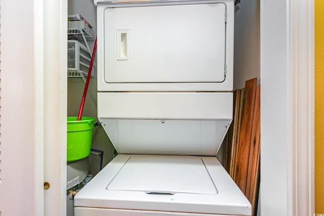 washroom featuring stacked washer / drying machine