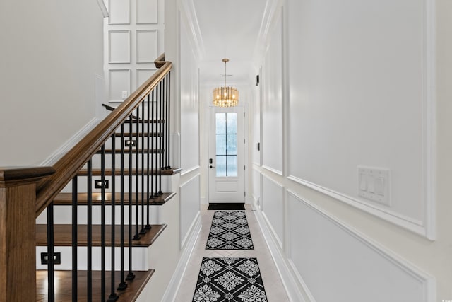 interior space with light tile patterned floors, an inviting chandelier, and ornamental molding