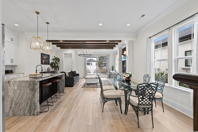 dining room featuring a chandelier, beam ceiling, crown molding, and light hardwood / wood-style flooring