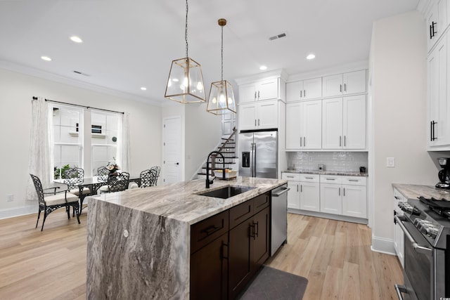 kitchen with white cabinets, stainless steel appliances, and hanging light fixtures