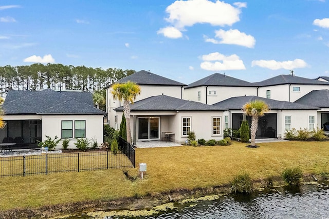 back of house featuring a water view and a yard