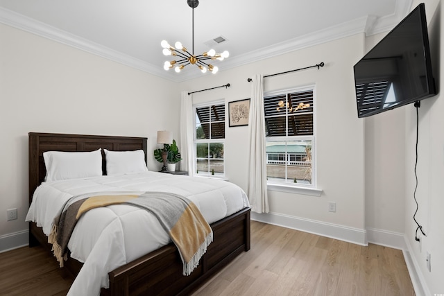 bedroom featuring crown molding, light hardwood / wood-style flooring, and a chandelier