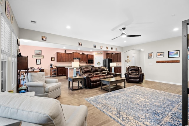 living room featuring ceiling fan and light wood-type flooring