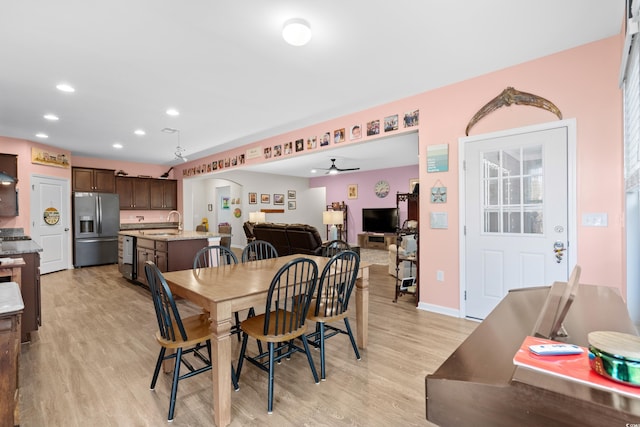 dining space featuring ceiling fan, light hardwood / wood-style floors, and sink