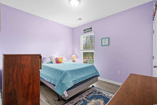 bedroom with dark wood-type flooring