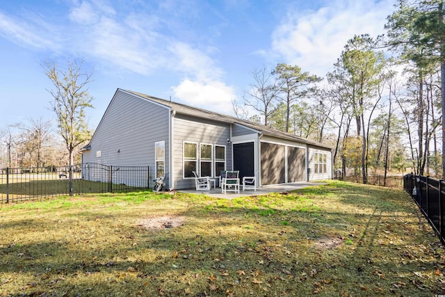 rear view of property with a sunroom, a patio area, and a lawn