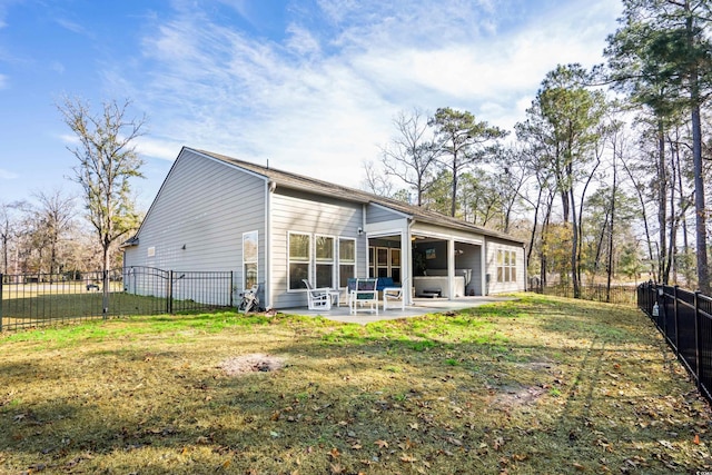 back of property with a lawn and a patio