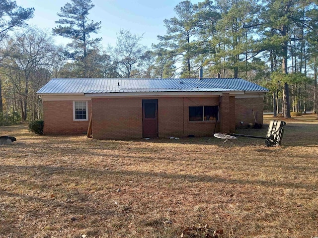 rear view of property featuring a lawn