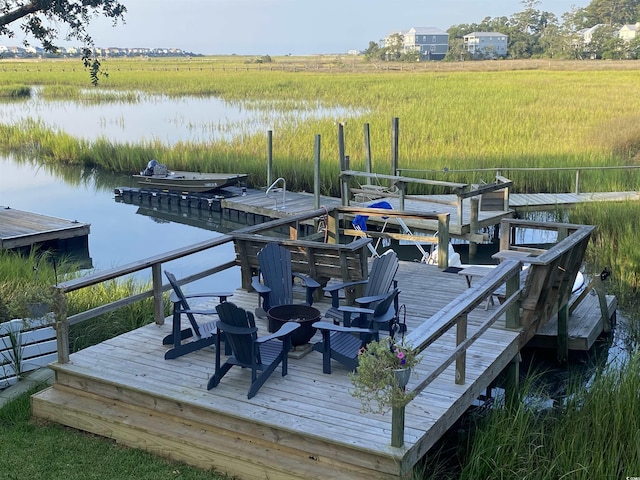 view of dock with a rural view and a water view