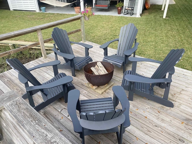 deck with an outdoor fire pit and a yard