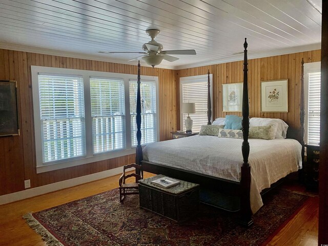 bedroom featuring ceiling fan, access to exterior, a water view, french doors, and wood walls