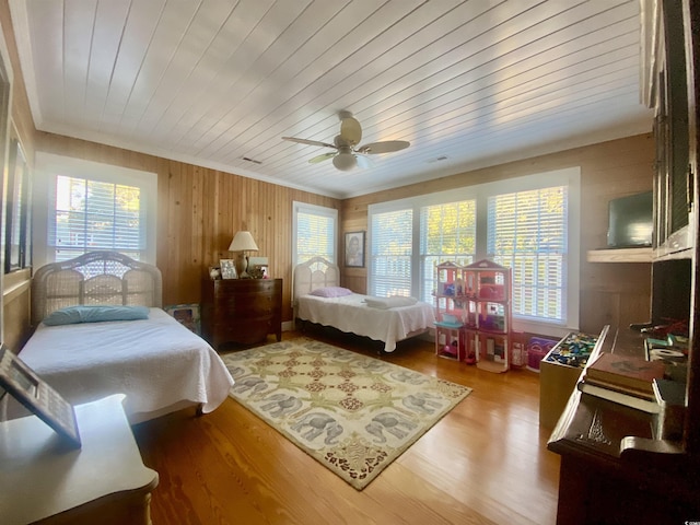 bedroom featuring light wood finished floors, wooden ceiling, and ornamental molding