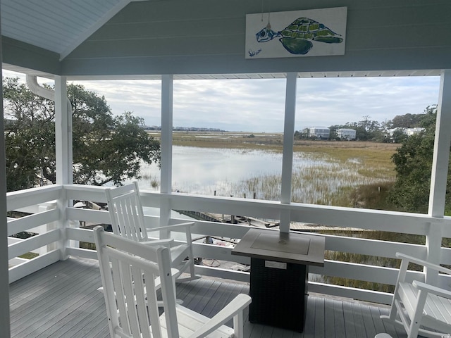 sunroom featuring a water view, plenty of natural light, and vaulted ceiling