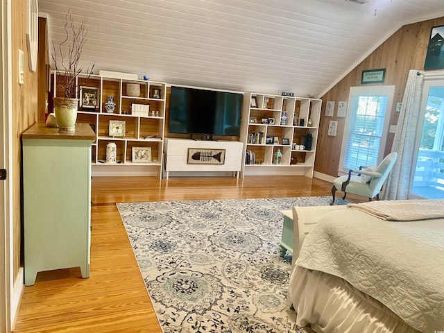 interior space featuring wood walls, wood finished floors, and vaulted ceiling