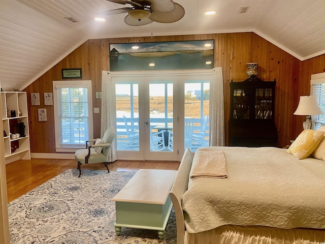 bedroom featuring visible vents, access to outside, wood finished floors, wood walls, and lofted ceiling