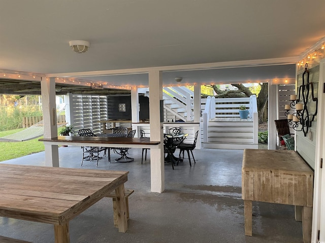 unfurnished dining area featuring concrete floors and stairs