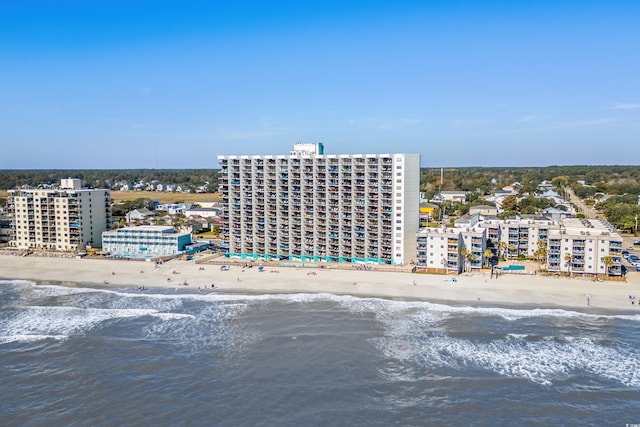 drone / aerial view featuring a view of the beach, a water view, and a city view