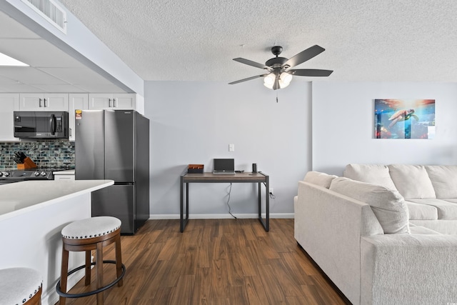 interior space with visible vents, white cabinets, dark wood finished floors, open floor plan, and freestanding refrigerator