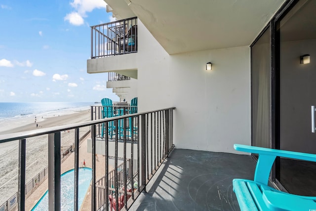 balcony featuring a view of the beach and a water view