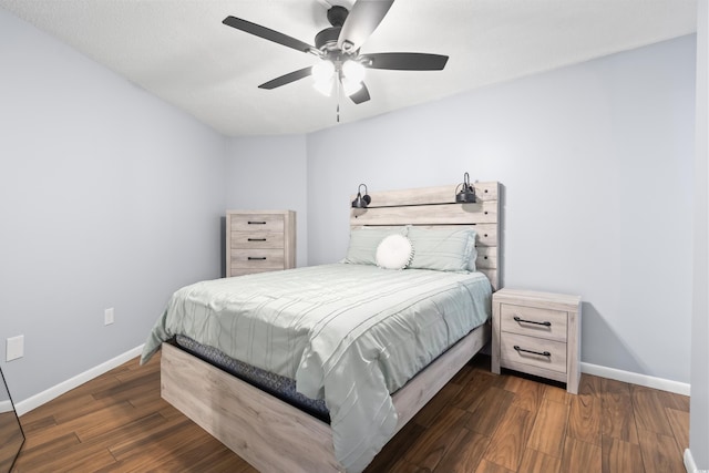 bedroom featuring dark wood-type flooring, baseboards, and a ceiling fan