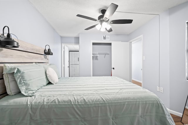 bedroom featuring baseboards, visible vents, ceiling fan, wood finished floors, and a textured ceiling