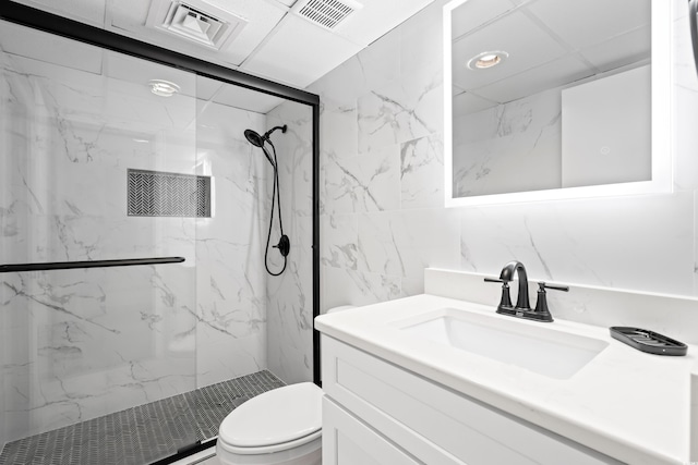 full bath featuring toilet, vanity, visible vents, tile walls, and a marble finish shower