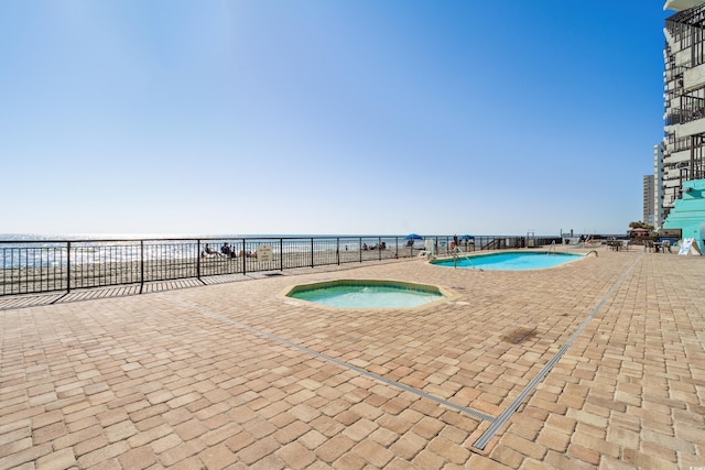 pool featuring a patio area, fence, and a hot tub