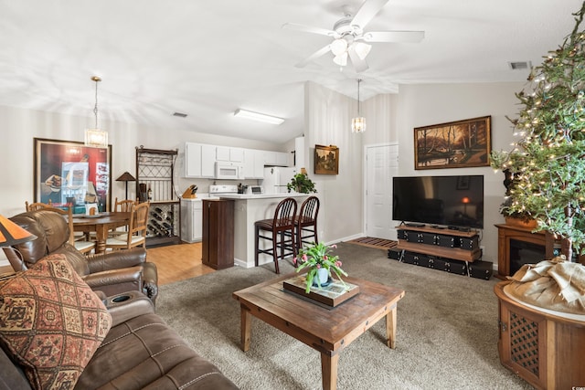 living room with ceiling fan, light carpet, and vaulted ceiling