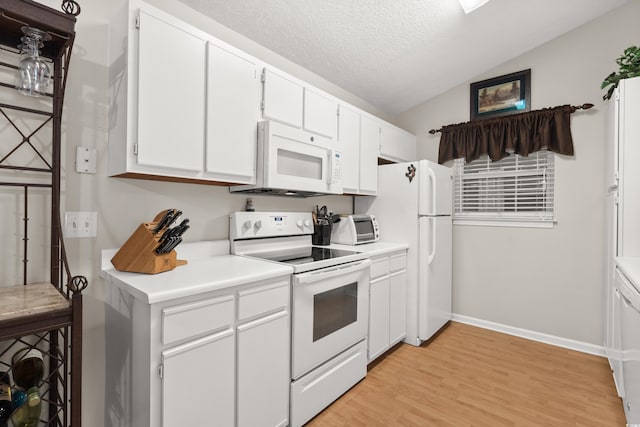 kitchen featuring vaulted ceiling, a textured ceiling, white cabinets, and white appliances