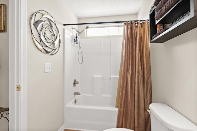 bathroom with toilet, a textured ceiling, and shower / tub combo with curtain