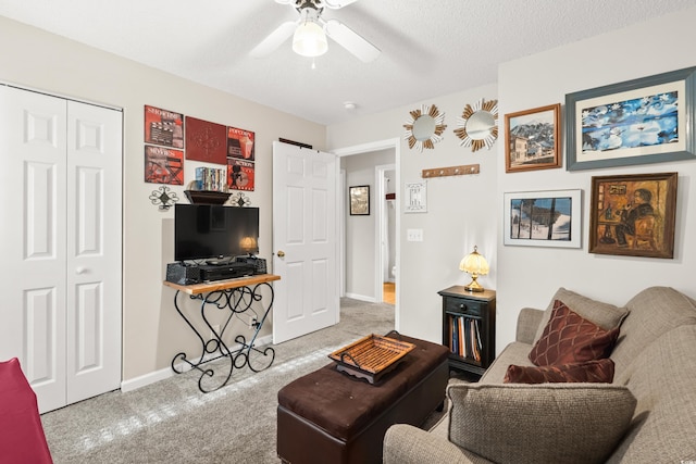 living room featuring a textured ceiling, light colored carpet, and ceiling fan