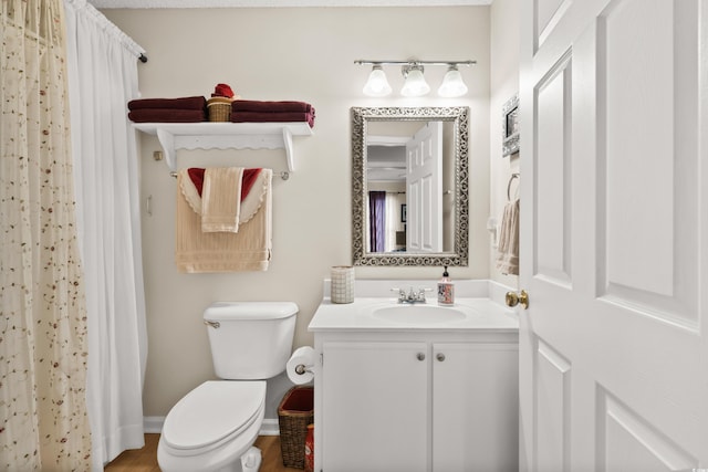 bathroom with curtained shower, vanity, and toilet