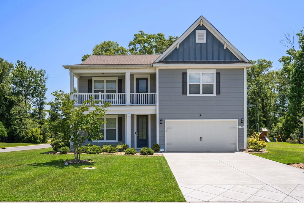 view of front of house with a balcony, a front yard, and a garage