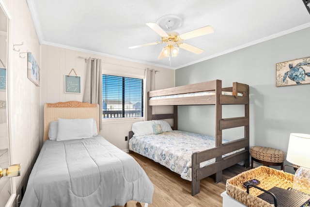 bedroom with light hardwood / wood-style flooring, ceiling fan, and ornamental molding