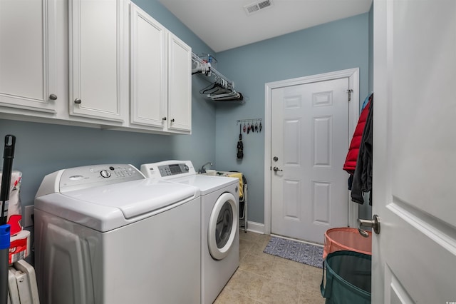 clothes washing area with cabinets, washer and clothes dryer, and light tile patterned flooring